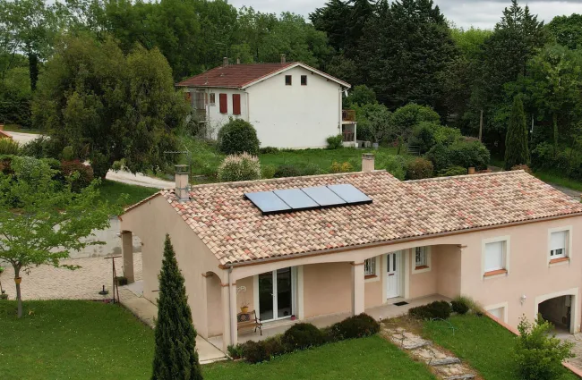 Maison orange avec 4 panneaux solaires thermiques
